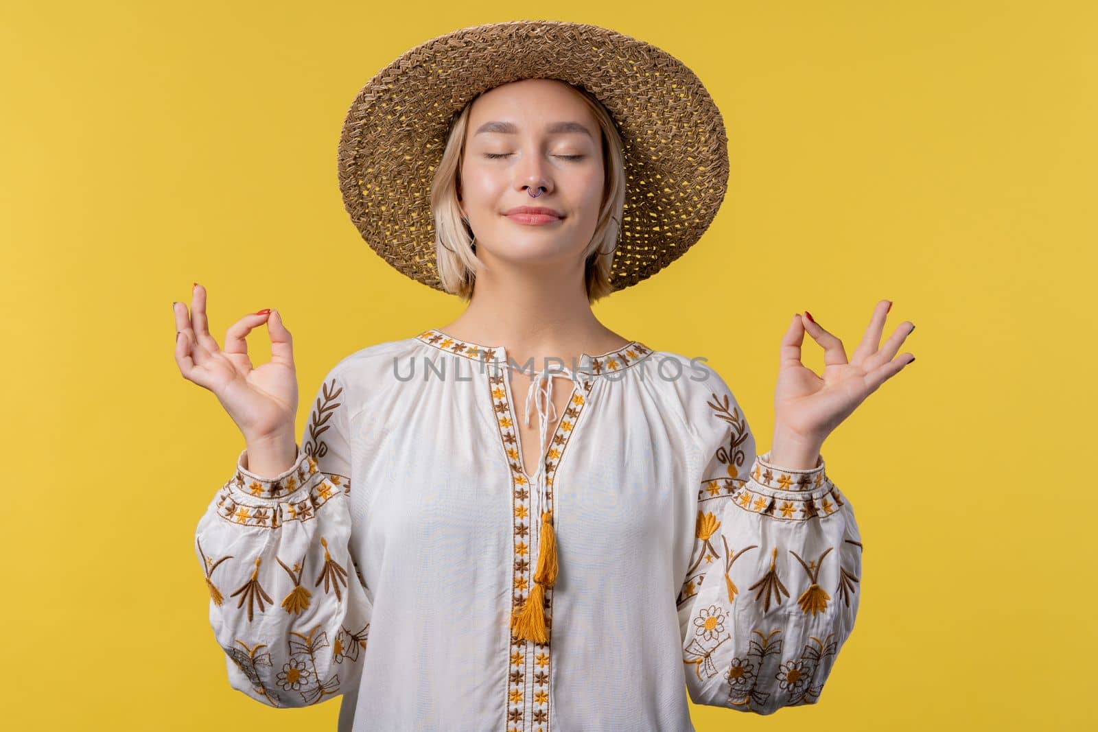 Calm ukrainian woman relaxing, meditating, refuses stress. Sunny girl breathes deeply, calms down yellow studio background. Yoga, moral balance, zen concept. by kristina_kokhanova