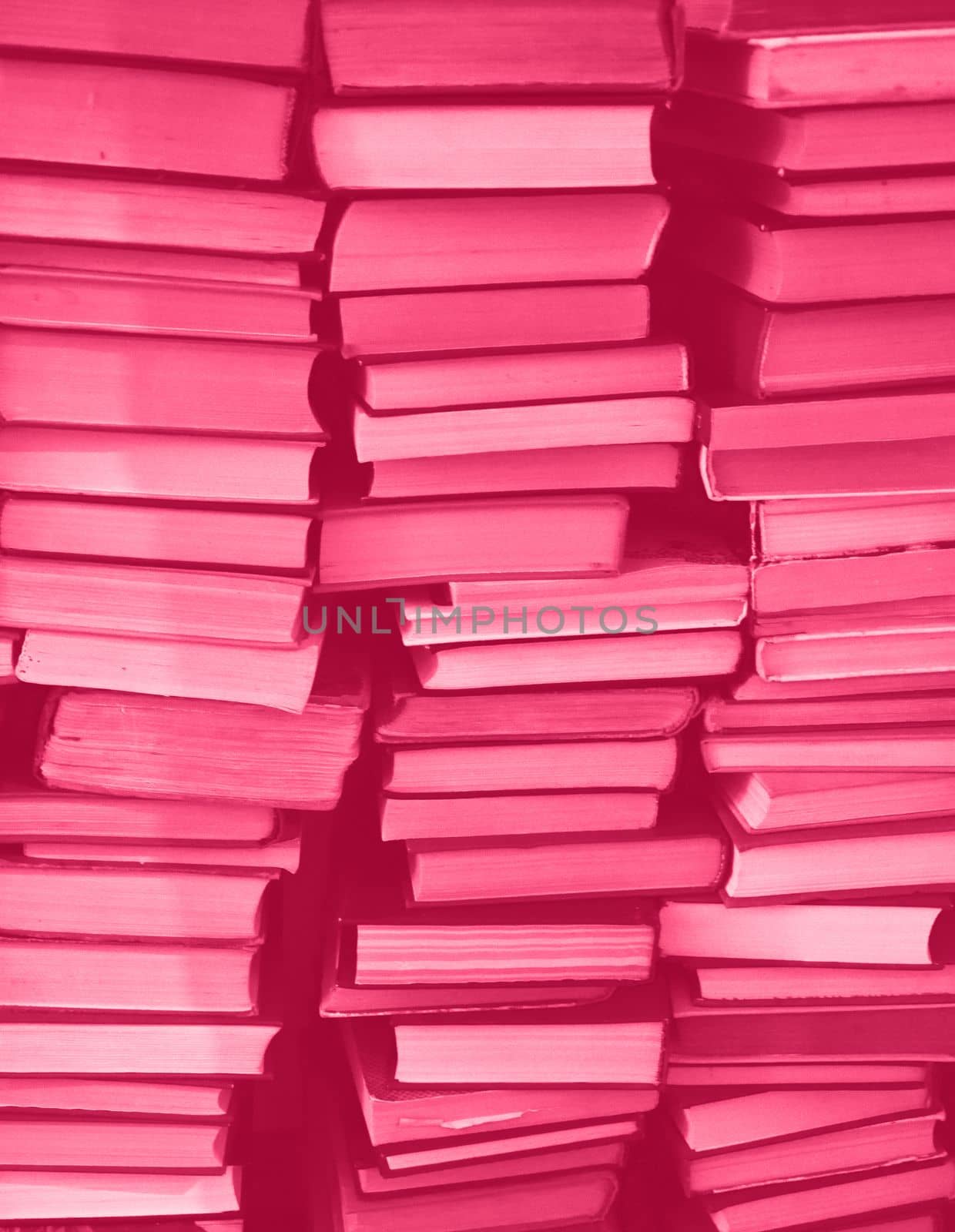 Viva Magenta colour chaotic stack of old books background. Background from old books that are exhibited in a chaotic manner. Colour of the year 2023. Trendy Viva Magenta color. High quality photo