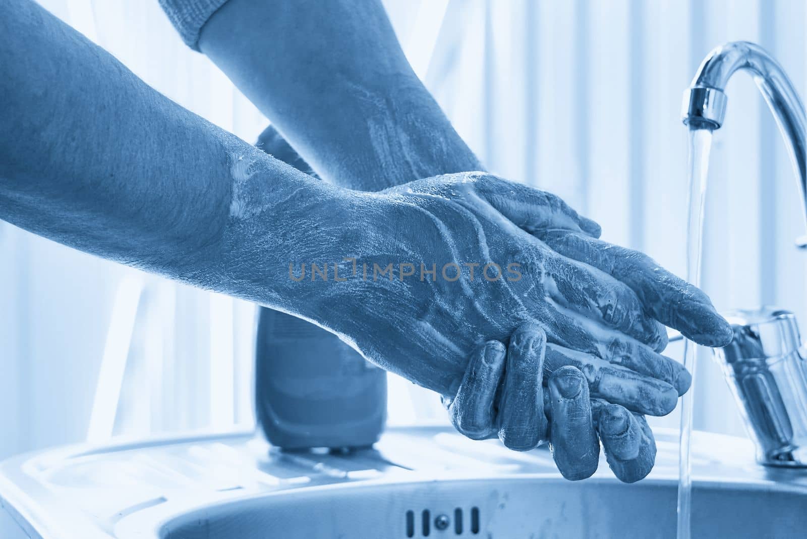 Mechanic washing dirty hands with a soap after work