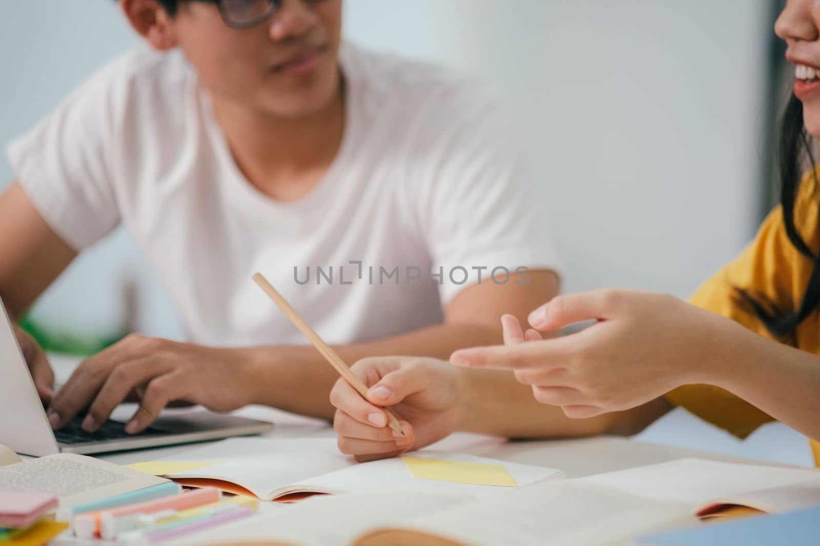 Young woman and man studying for a test or an exam. Tutor book with friends. Young students campus or classmates helps friend catching up workbook and learning tutoring in classroom, teaching, learning