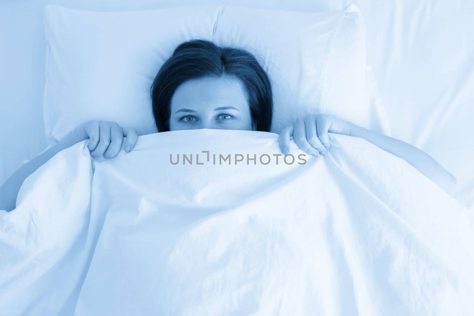Portrait of young beautiful woman in cozy bed
