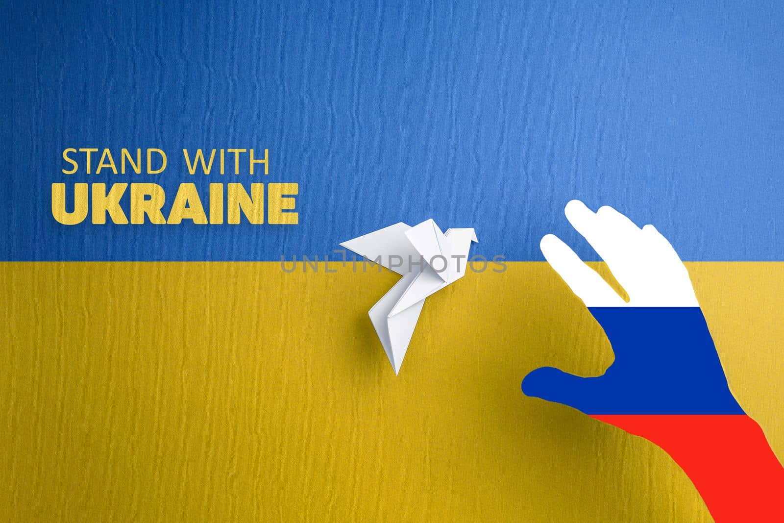 hand with colors of russian flag catches paper dove on yellow and blue background with words stand with Ukraine. terror and annexation