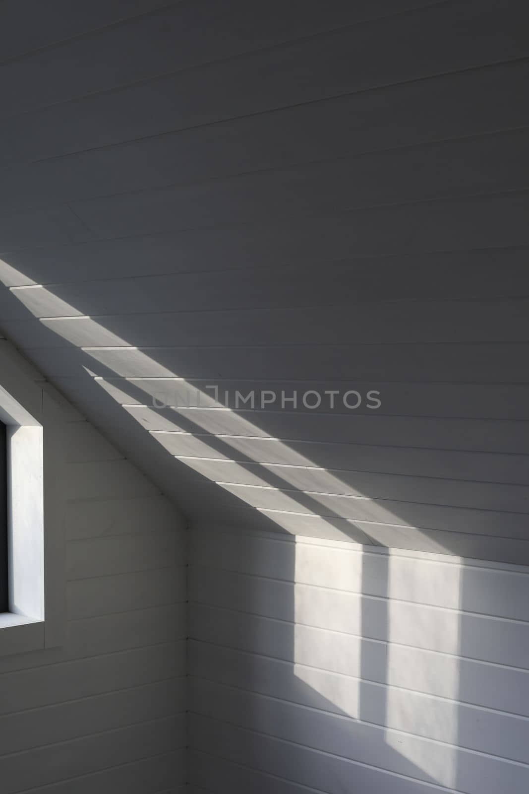 Sunlight on the white wooden wall background with shadows from the window. White room, texture and pattern