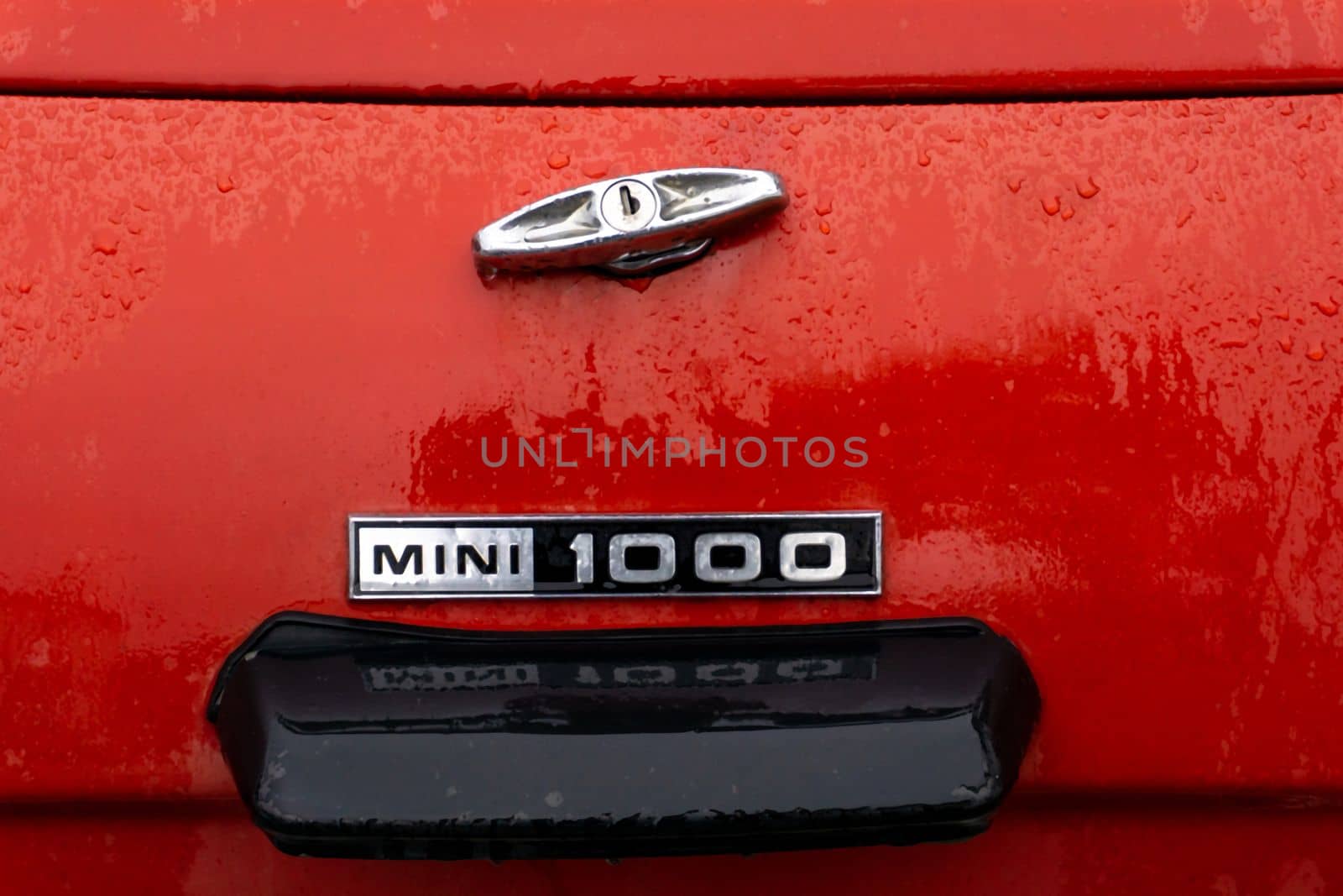 The trunk of a red retro car in raindrops close up