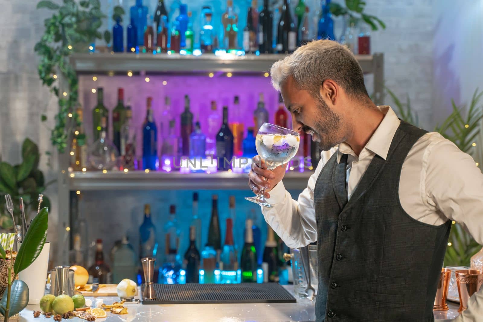 Professional barman smelling cocktail in nightclub. Night life concept. High quality photo