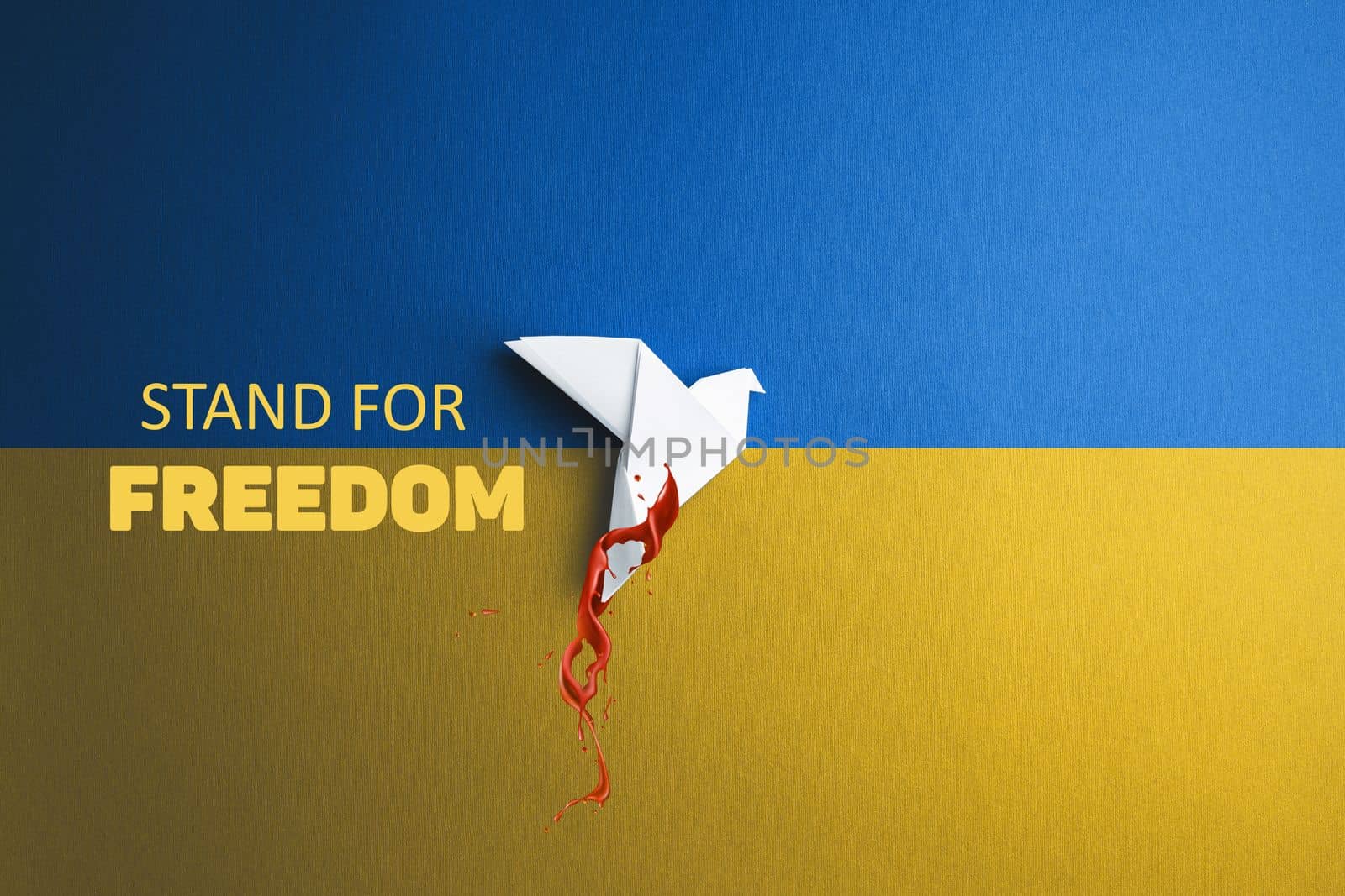 words stand for freedom and paper origami dove in blood takes off and breaks free on yellow blue background
