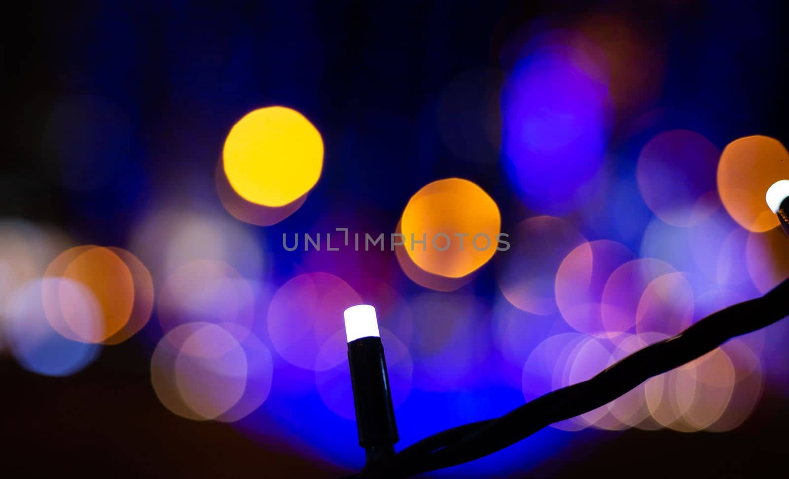 Small electric garland on a bokeh of glowing lights background. by gelog67