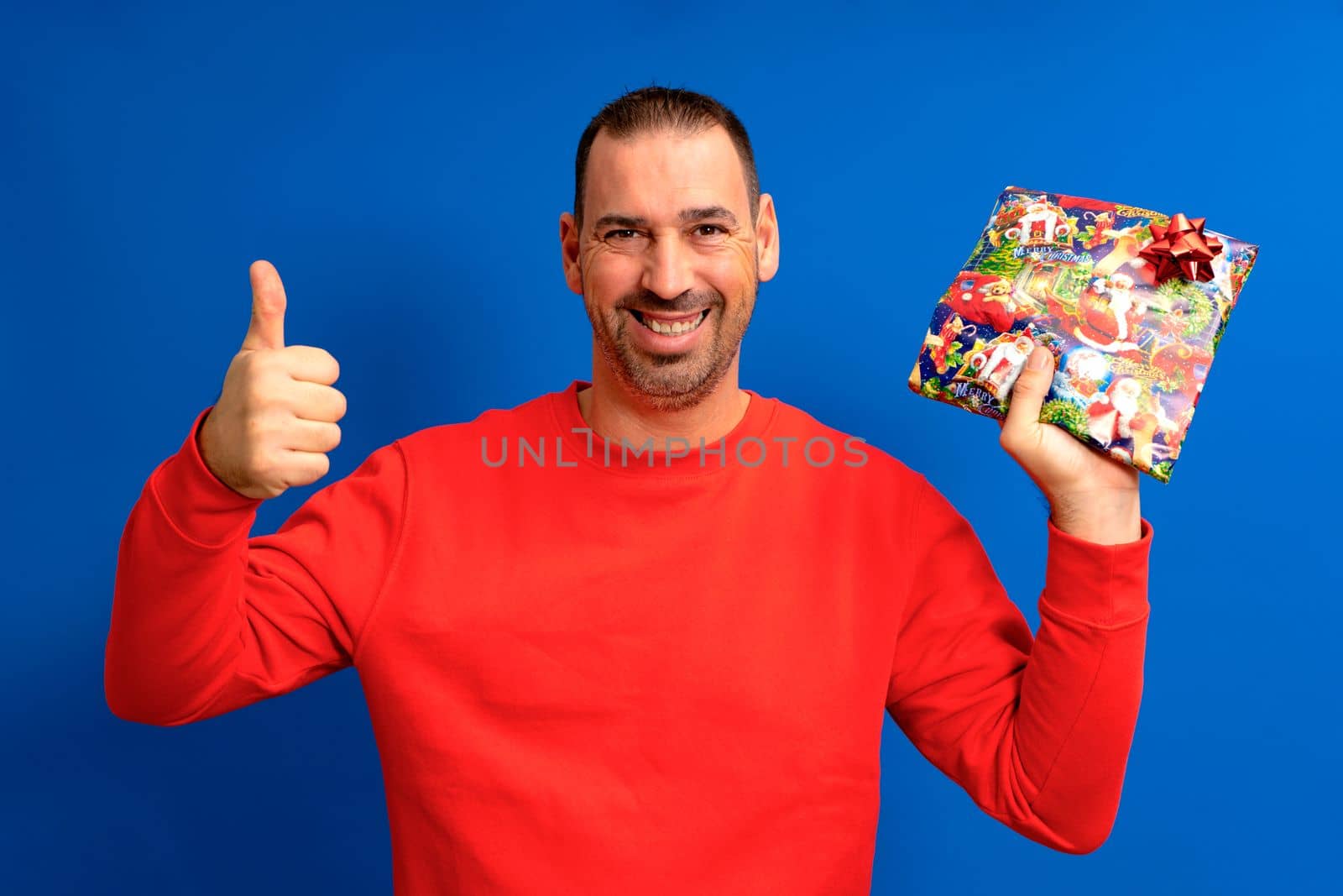 The best gift. Happy man holds a gift showing thumb up. Gift or gift box. Celebrating birthday anniversary. Special occasion. Preparation and celebration of holidays.