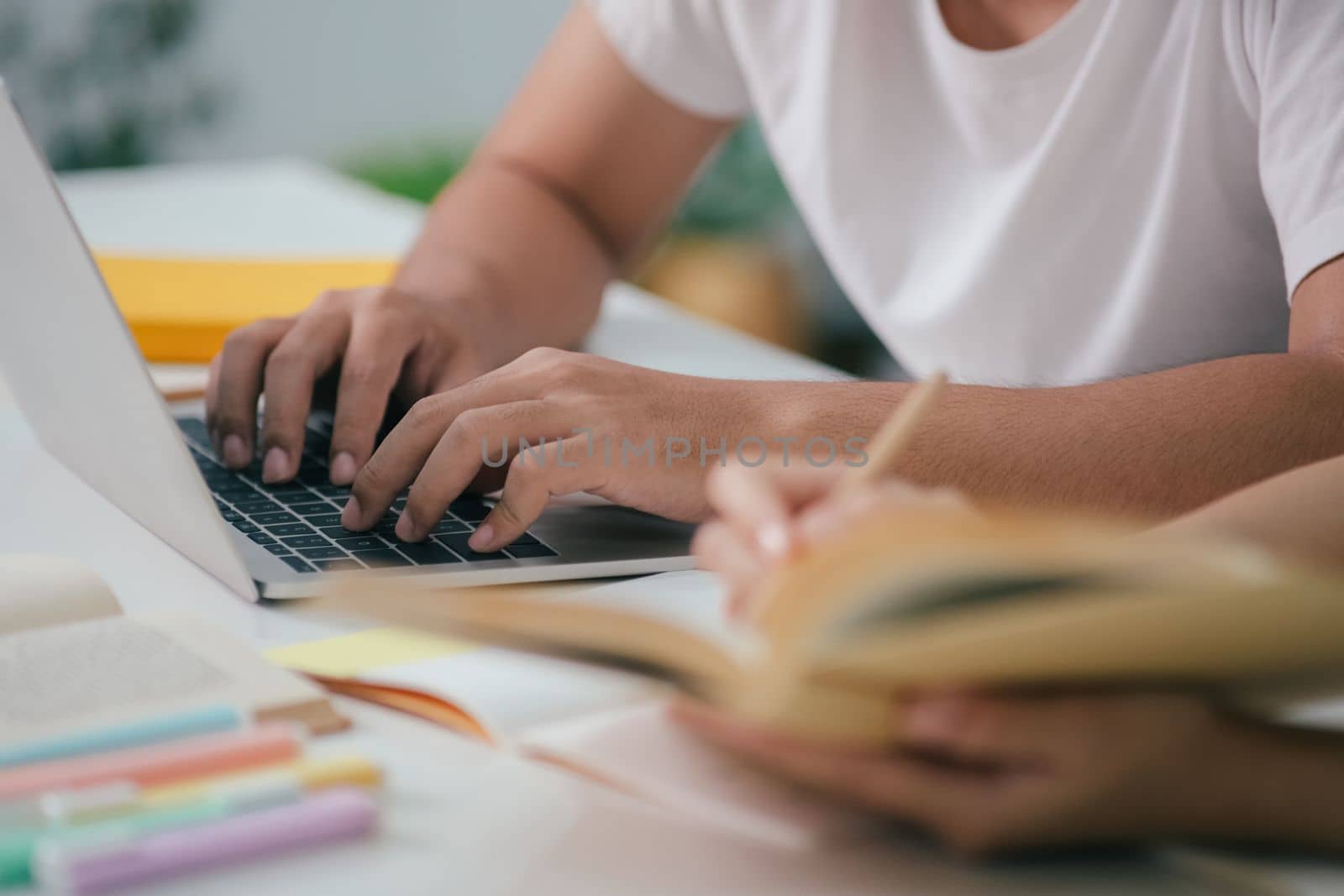 Young woman and man studying for a test or an exam. Tutor books with friends. Young students campus helps friend catching up and learning.