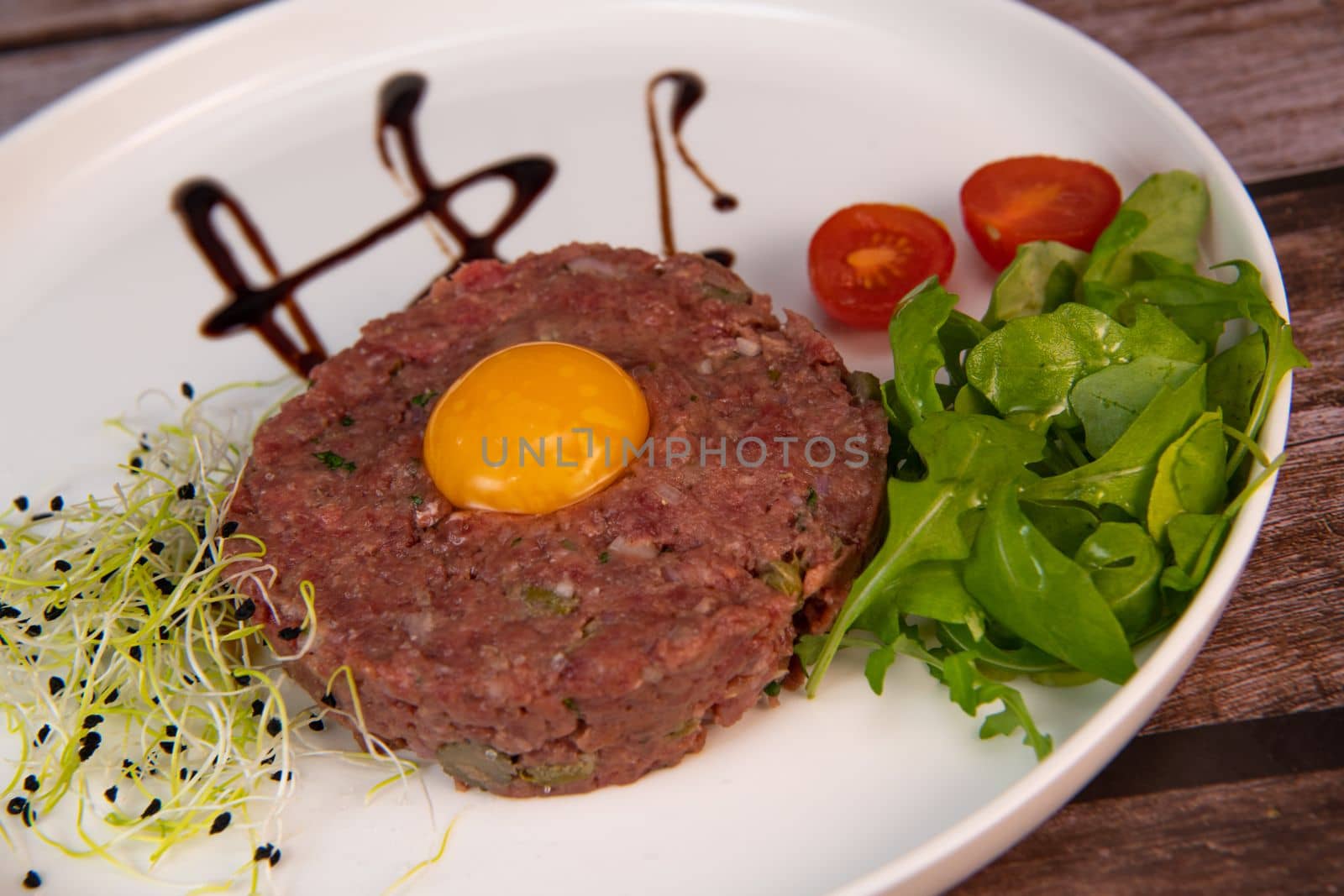 Steak Tartare with vegetables salad and french fries on dish. High quality photo