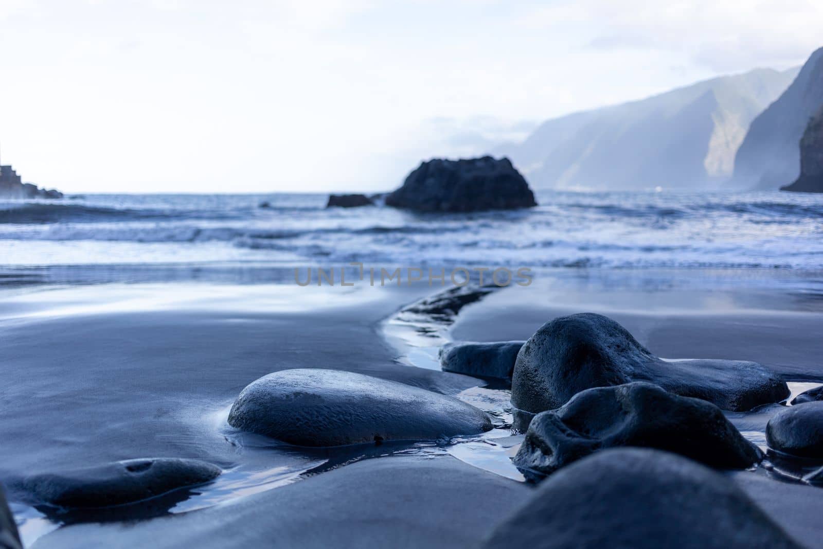 black sand beach of Madeira view on mountains by Chechotkin