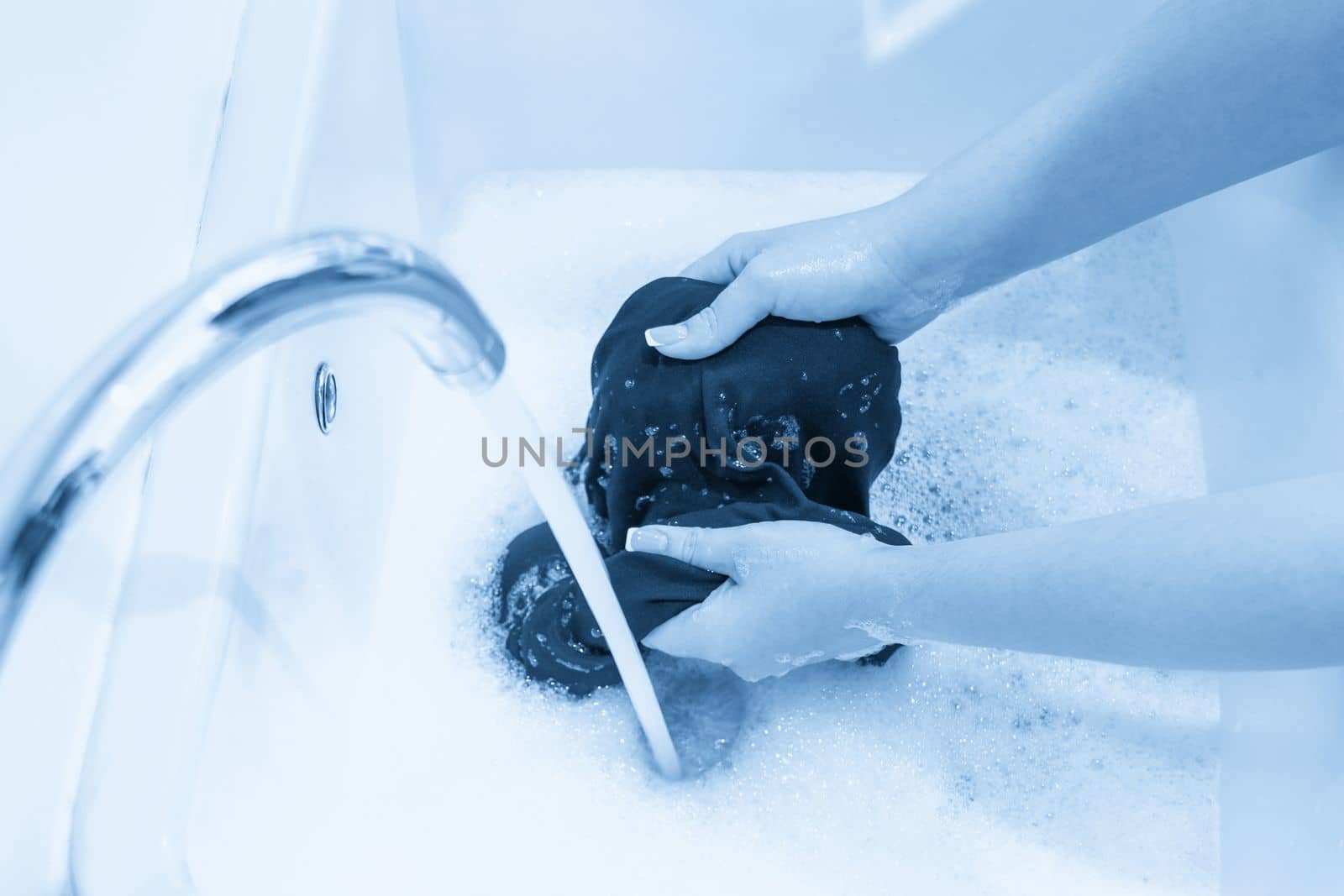 Female hands washing clothes in basin