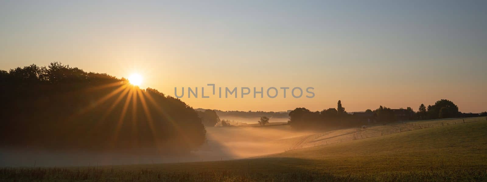 Panoramic landscape image of sunrise on a foggy morning during autumn, Bergisches Land, Germany