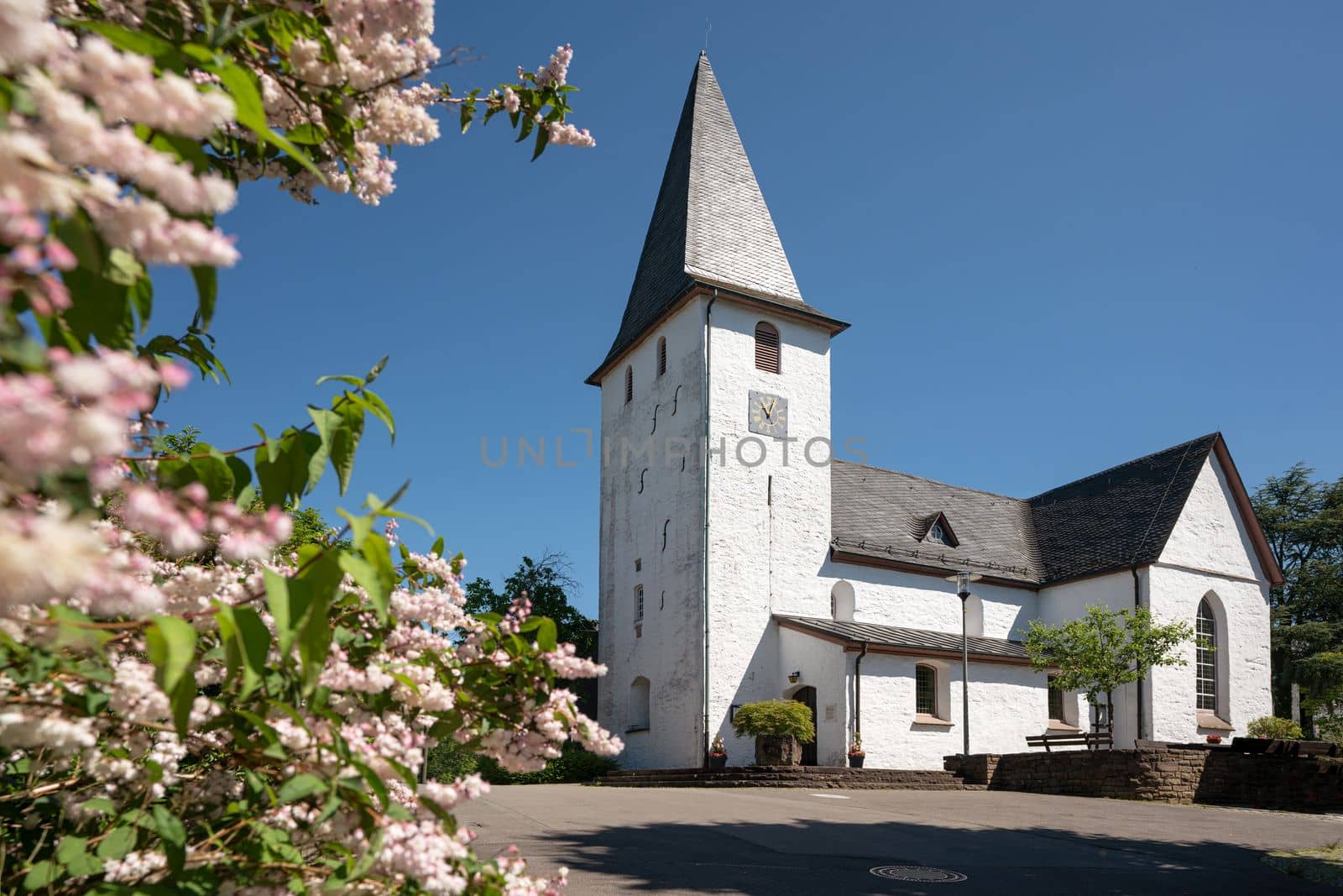 Panoramic image of  Lieberhausen church with blooming trees during summer, Bergisches Land, Germany