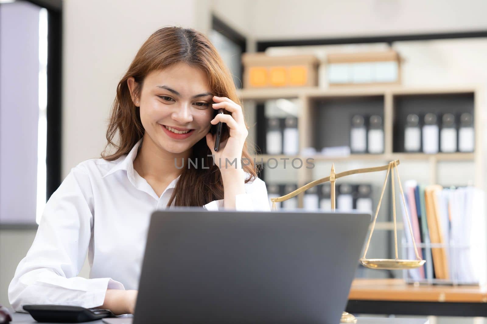 woman and lawyers discussing contract papers with brass scale on wooden desk in office. Law, legal services, advice, Justice and real estate concept.