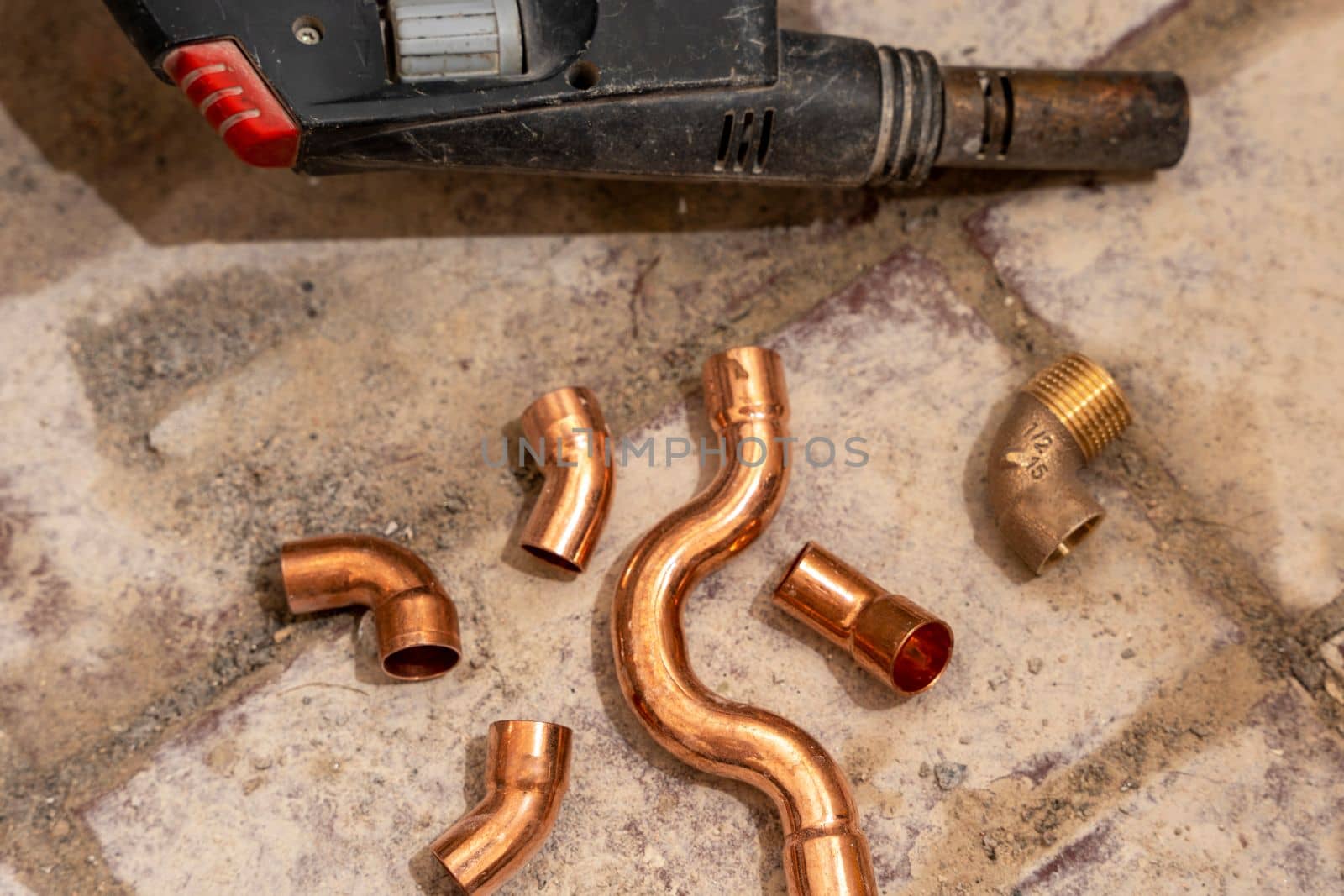 manual gas burner for household purposes for construction. Hand holding gas can with manual torch burner,blowtorch, for soldering copper pipes. concrete background