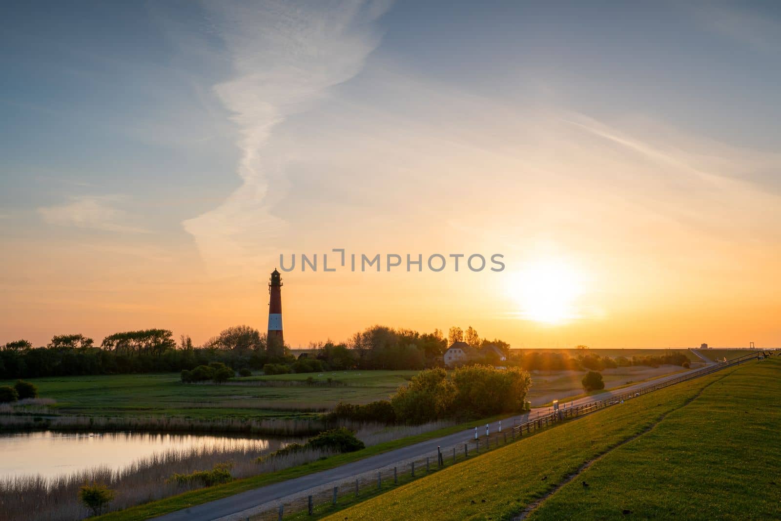 Panoramic image of Pellworm lighthouse against sunrise, North Frisia, Germany 