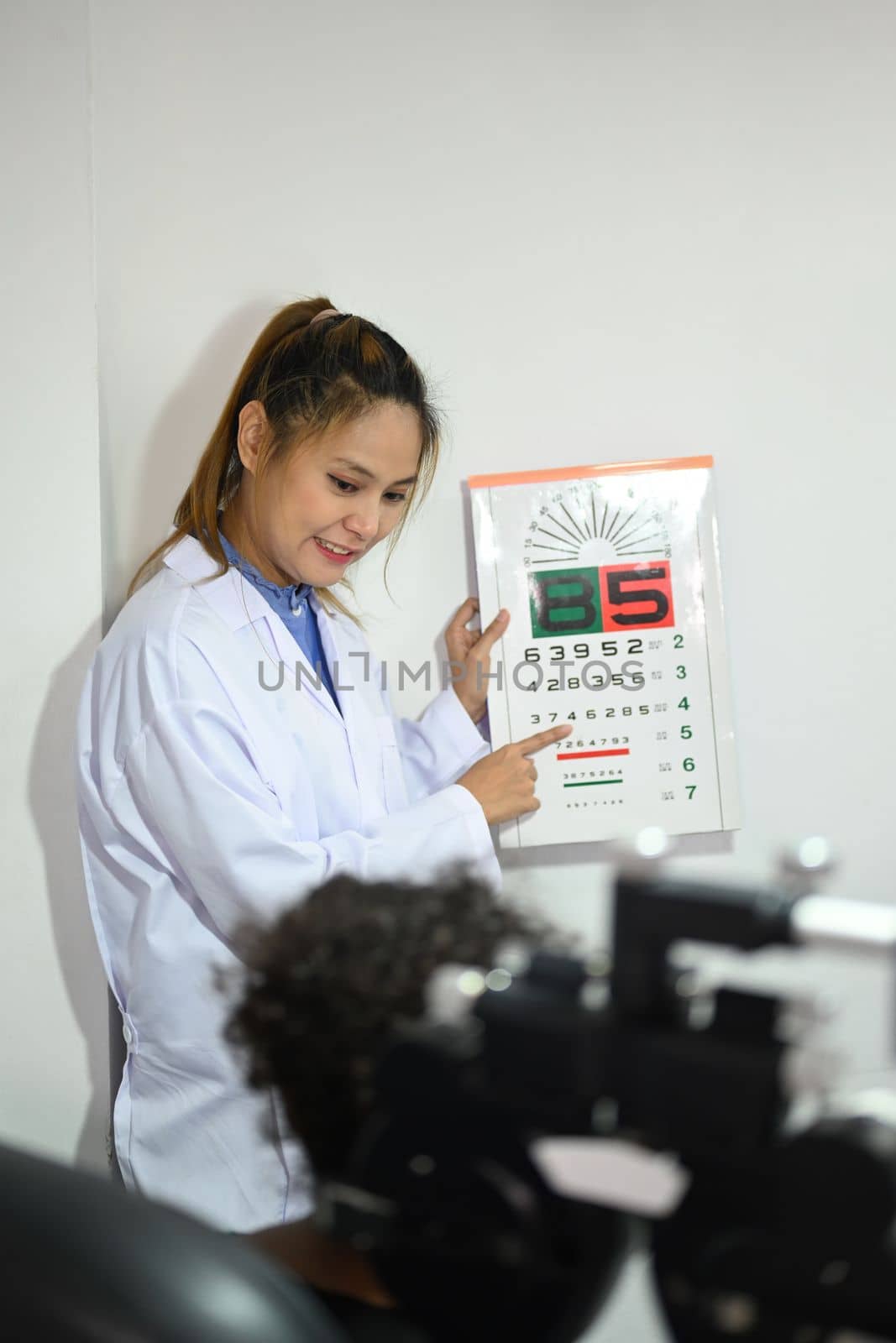 Shot of ophthalmologist checking child eyesight with ophthalmology measurements letters, for testing visual acuity by prathanchorruangsak