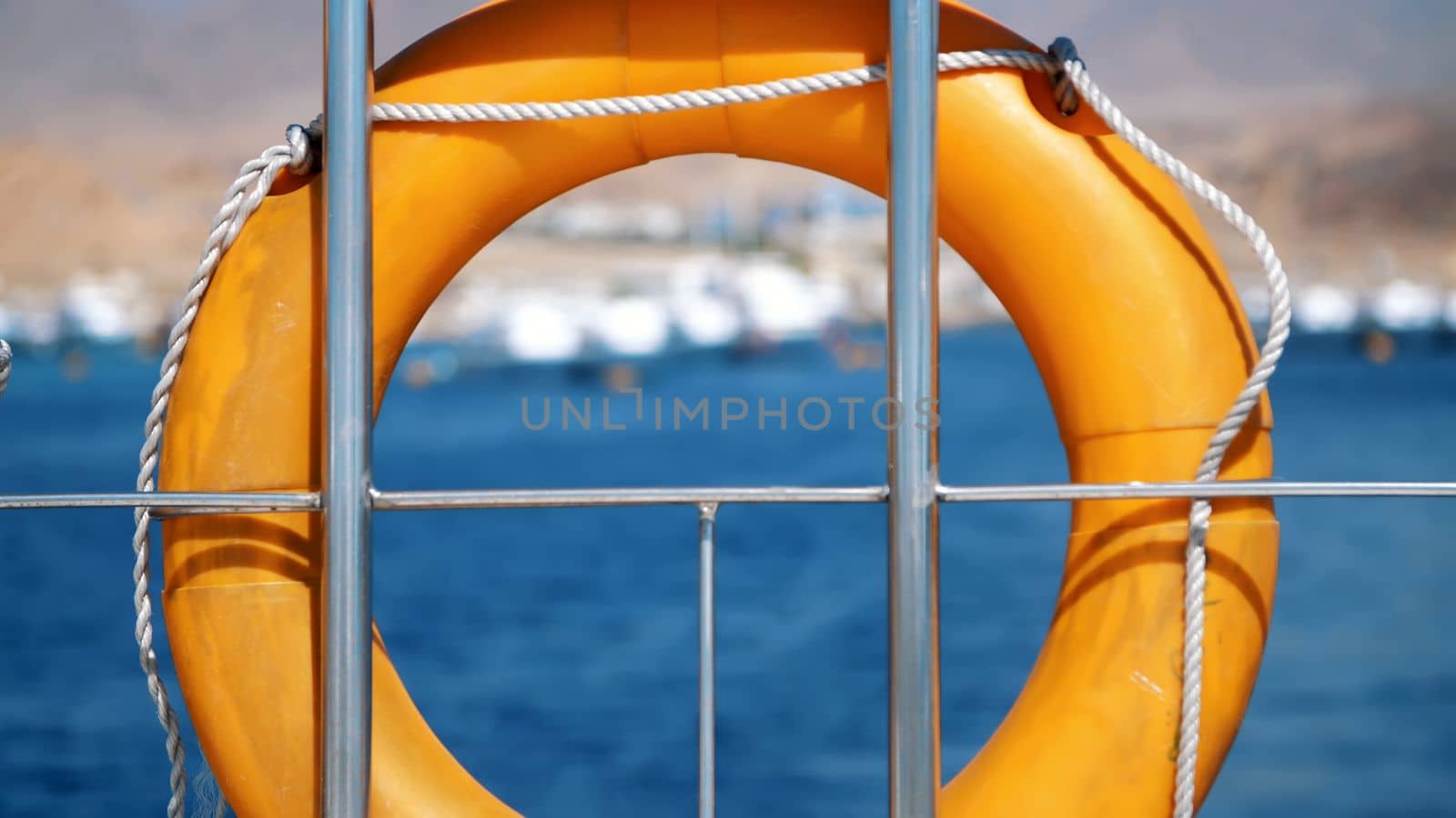 summer, sea, orange lifebuoy, hanging aboard a ferry, ship. special rescue equipment of the ship. saves the life of a person who is drowning. High quality photo