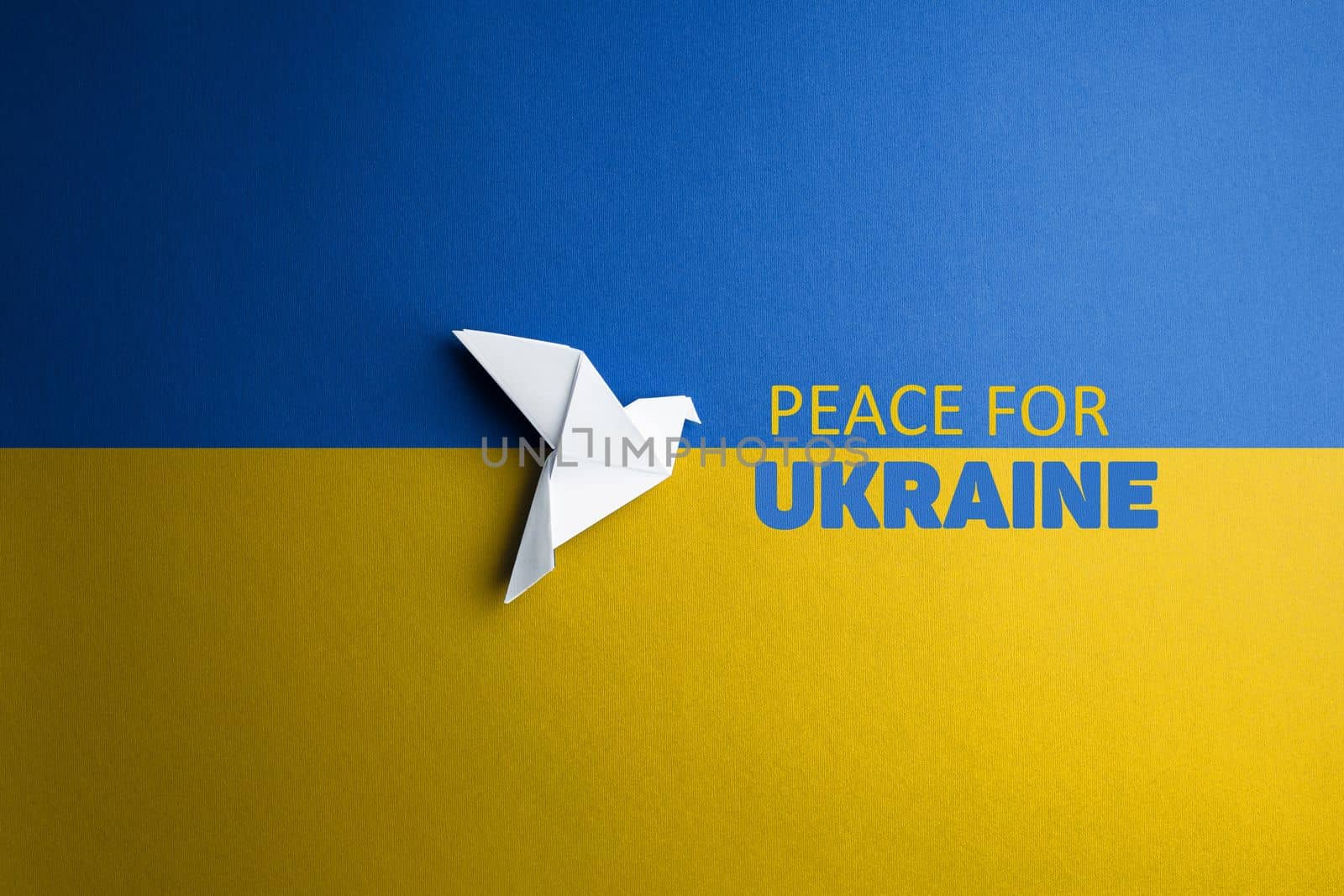 white paper dove bird on background of flag of ukraine with blue yellow color with words peace for Ukraine