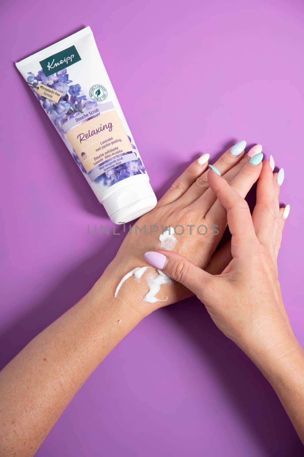 woman applies a jar of cleansing skin scrub to her hand,cosmetics daily rituals, exfoliante Kneipp cosmetics, Lavender and jojoba,woman testing shower scrub on handAs,Belgium, June 30,2022