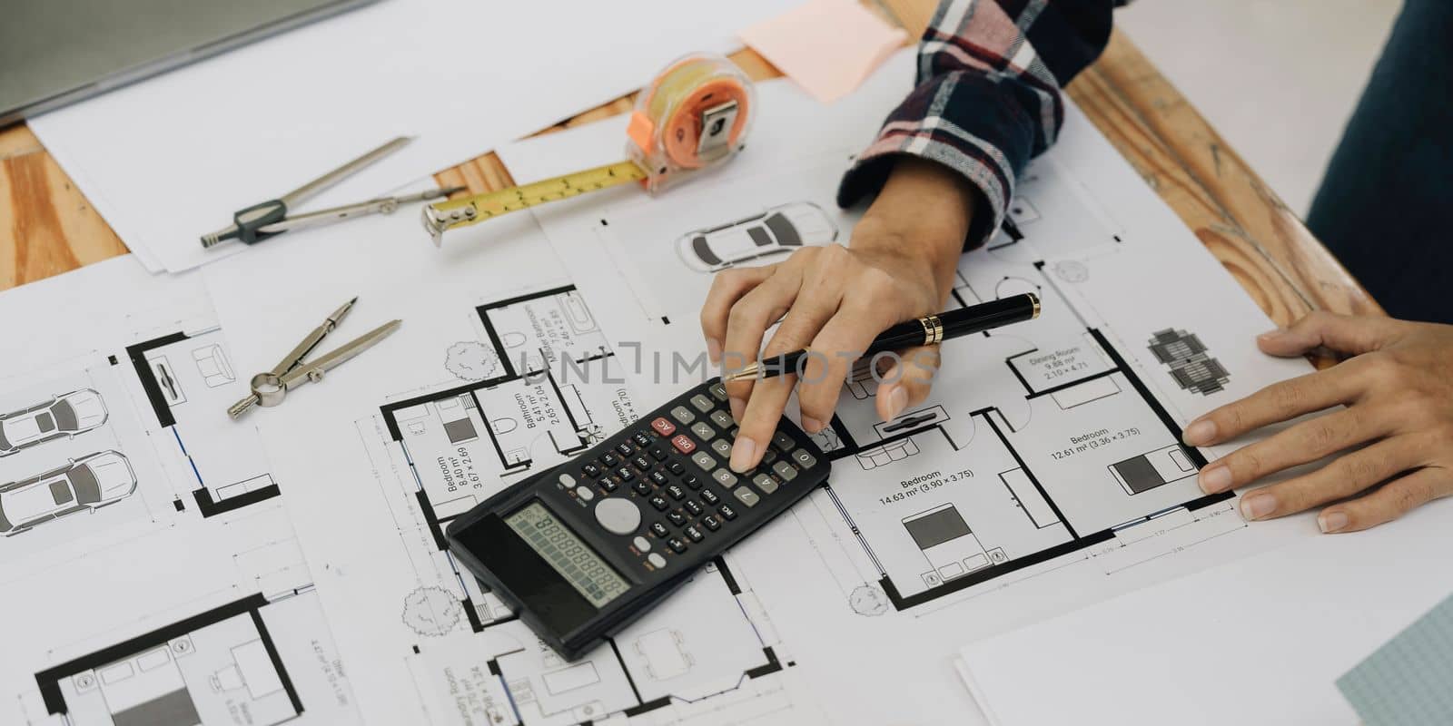 Concept architects, engineer holding pen pointing equipment architects On the desk with a blueprint in the office