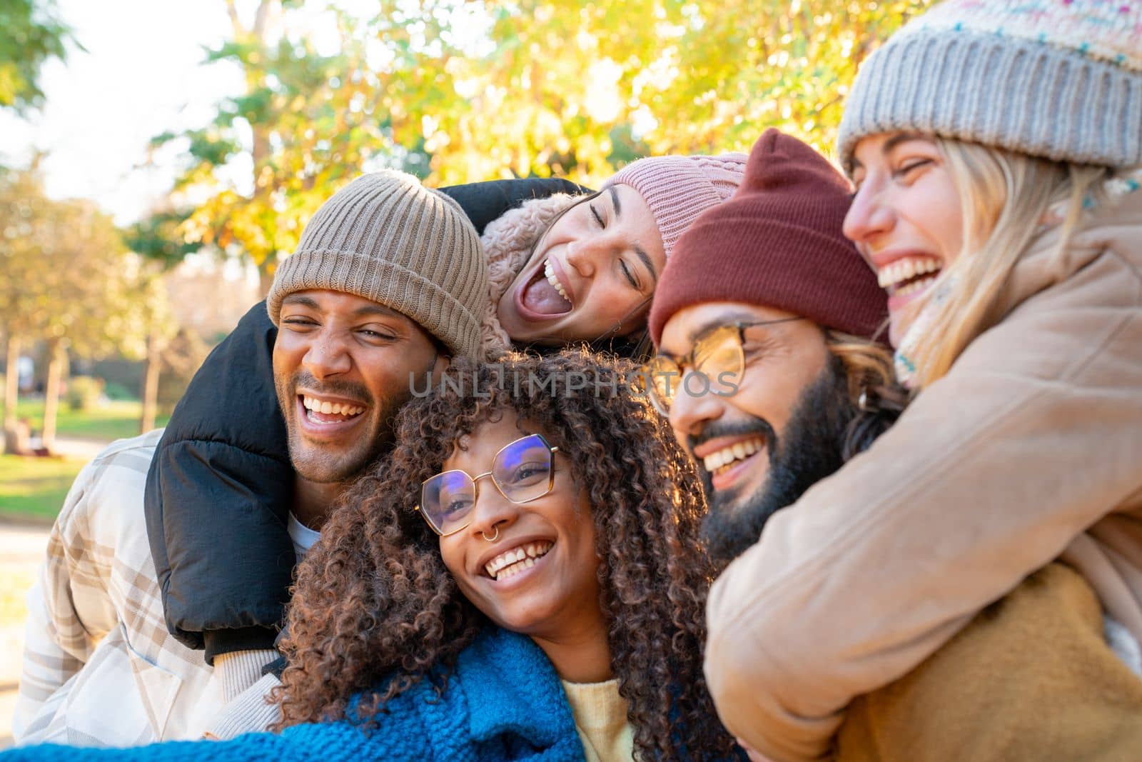 Cheerful group of friends taking smiling selfie. Happy people having fun together outdoors. by PaulCarr