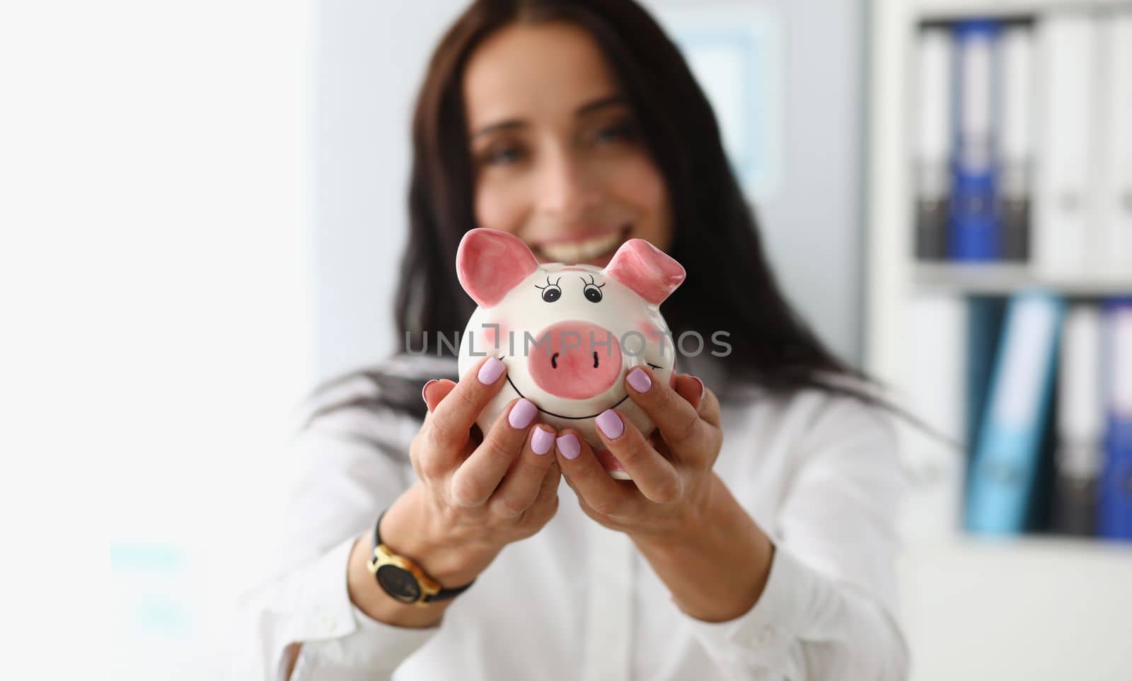Smiling businesswoman holding white pink piggy bank. Profitable deposit and investment concept