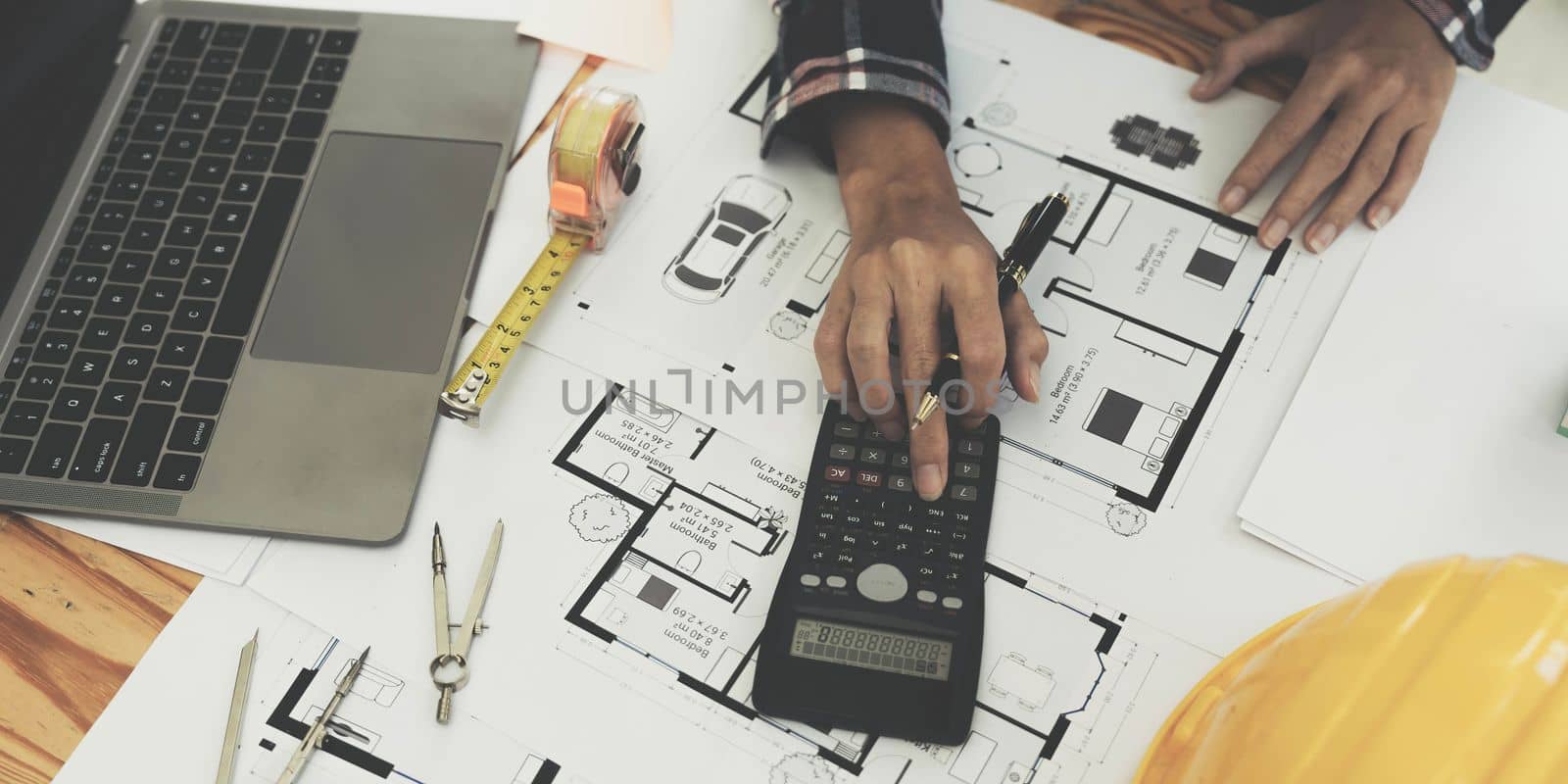 Concept architects, engineer holding pen pointing equipment architects On the desk with a blueprint in the office