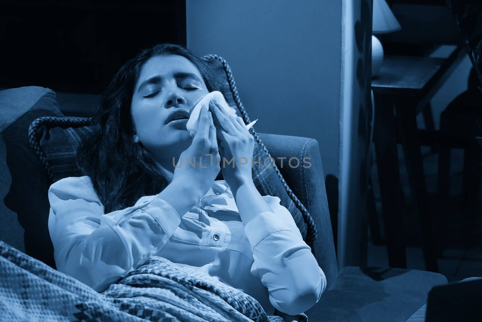 young woman on sofa covered with blanket freezing blowing running nose got fever, caught, sick girl having influenza symptoms, flu or virus concept