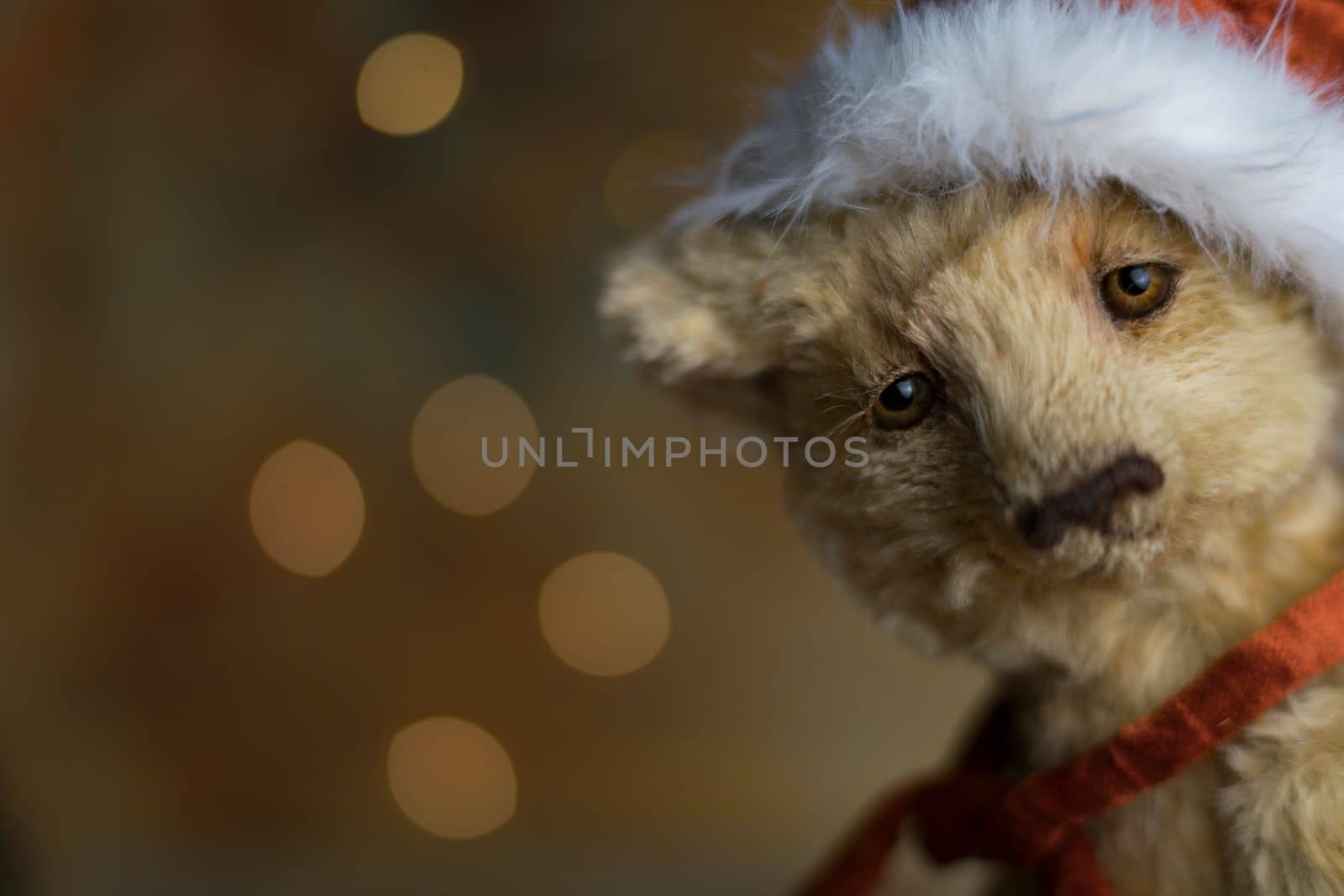 Christmas card greeting with cute handmade teddy bear with red Santa cap on brown background by Costin