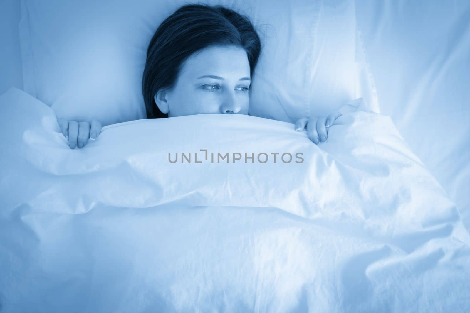 Portrait of young upset woman in bed, blue tone by Mariakray
