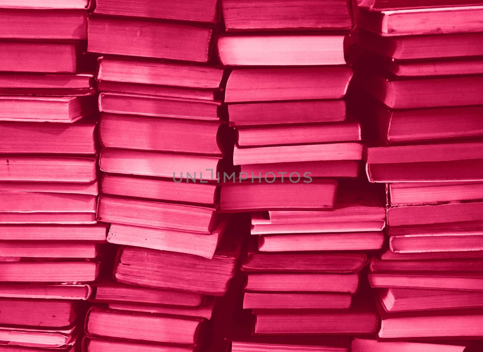 Viva Magenta colour chaotic stack of old books background. Background from old books that are exhibited in a chaotic manner. Colour of the year 2023. Trendy Viva Magenta color. High quality photo