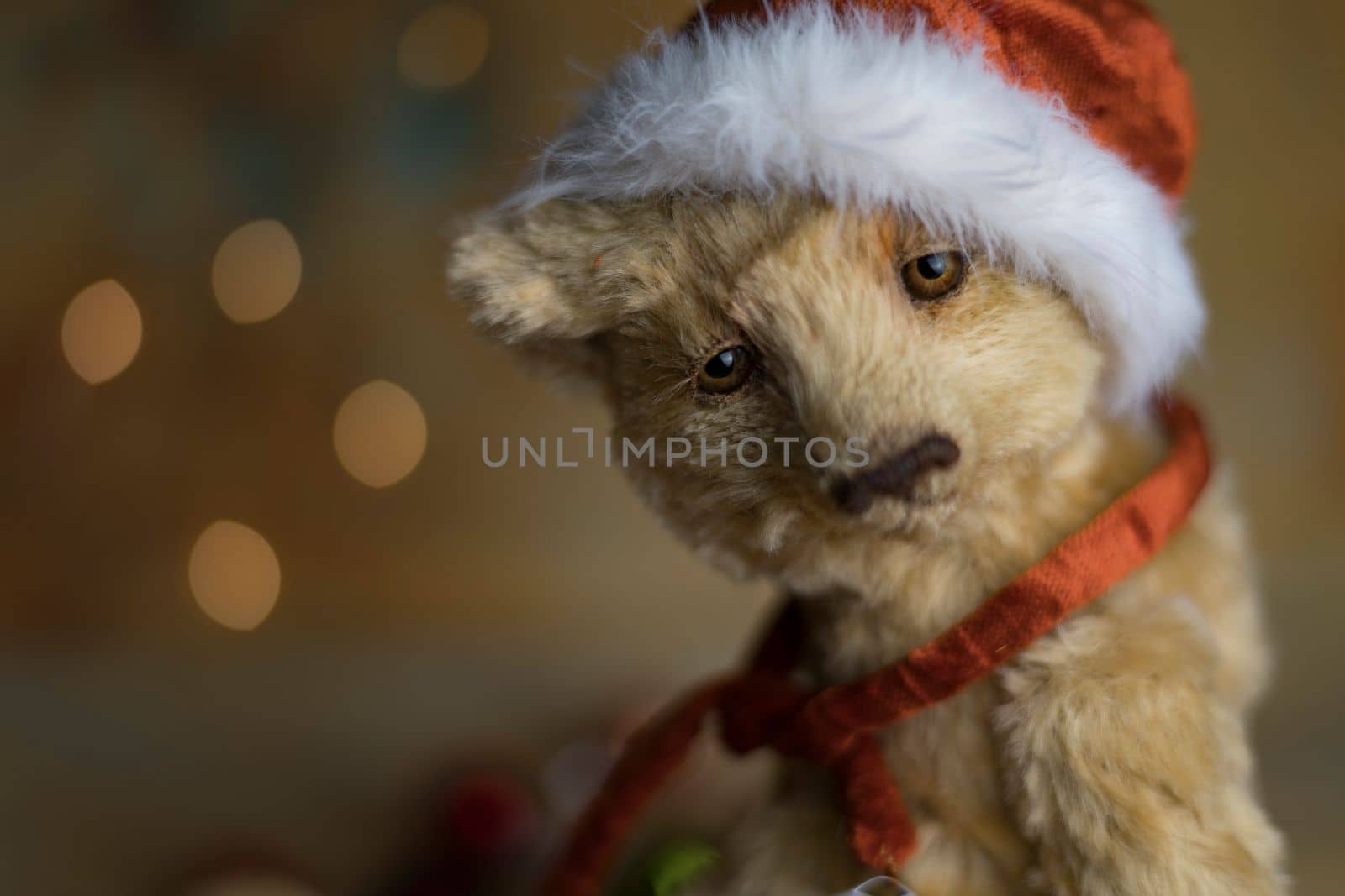 Christmas card greeting with cute handmade teddy bear with red Santa cap on brown background by Costin