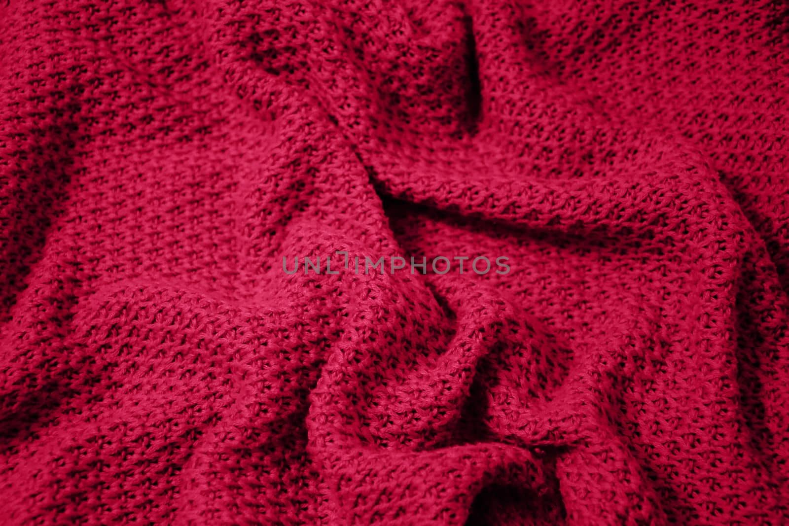 Viva Magenta toned colour monochrome texture knitted fabric. Dark pink knitted Jersey as textile background. Monochrome color background. Trendy color 2023.