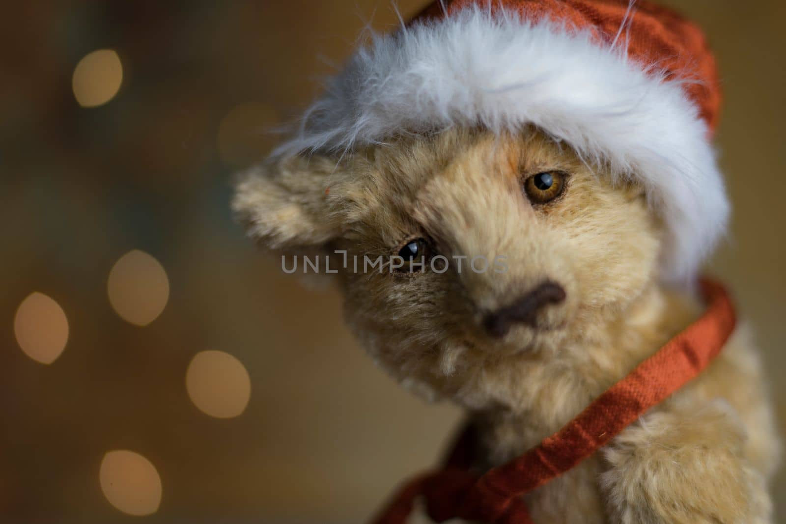 Christmas card greeting with cute handmade teddy bear with red Santa cap on brown background. high quality photo
