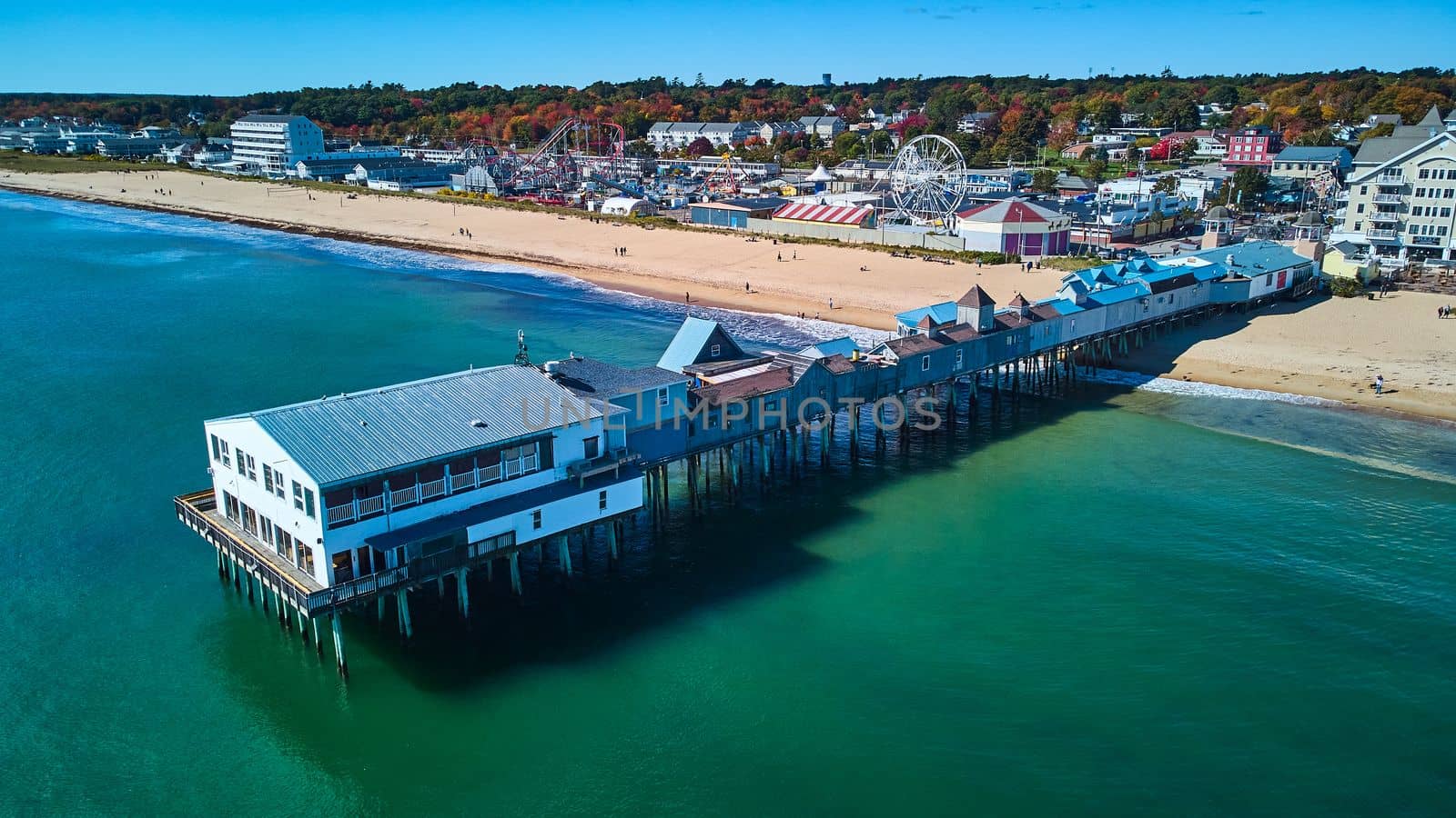 Aerial of Old Orchard Beach pier in fall over Maine ocean and view of beach and town by njproductions