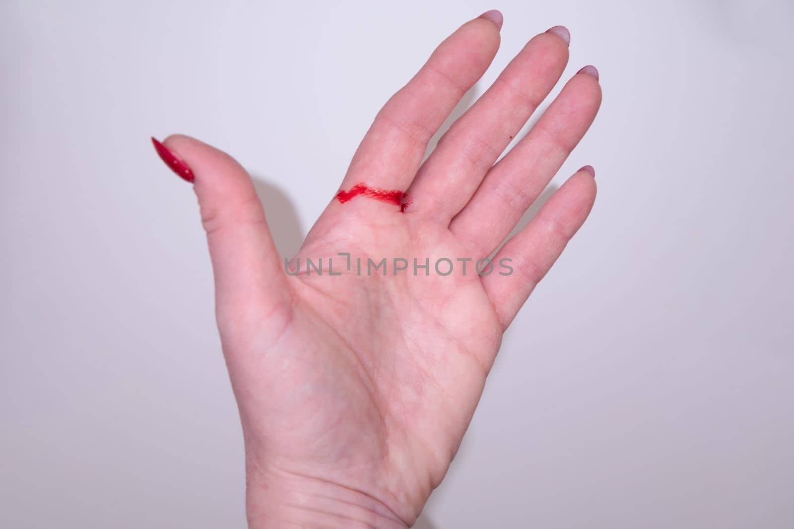 woman cut her hand with paper and gift wrapping red blood on her hand. High quality photo