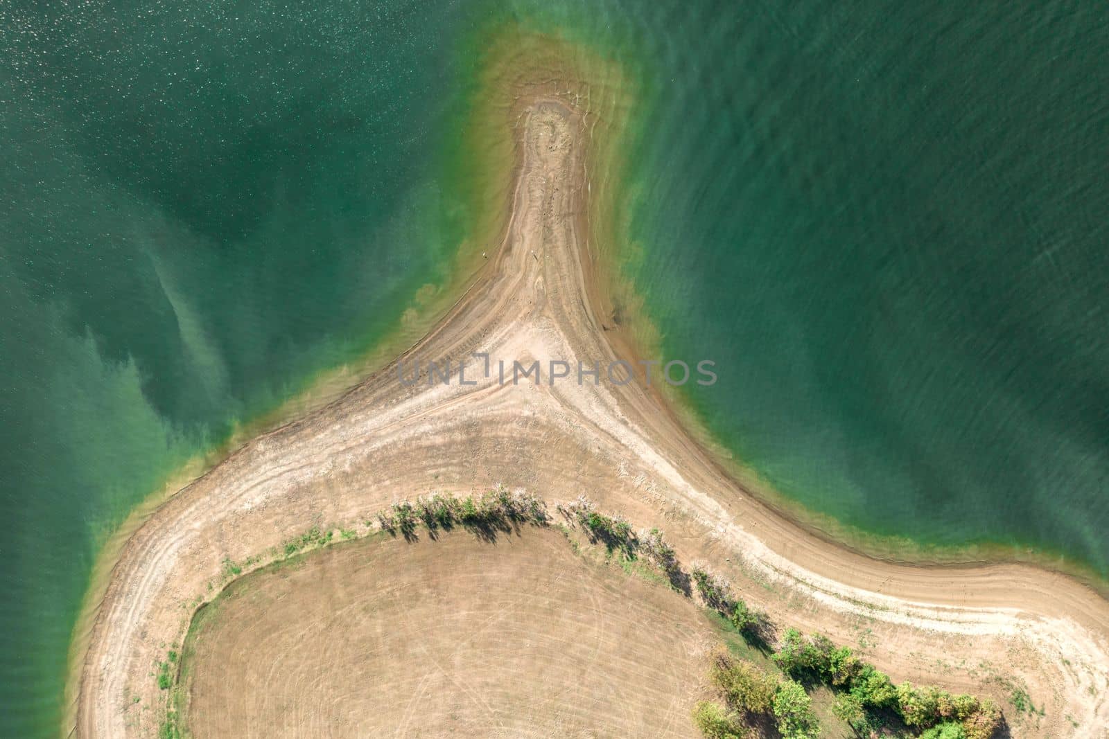 Aerial view of island with green trees surrounded by sea or ocean with clear water. Colorful landscape with beautiful nature. Tourism, traveling.