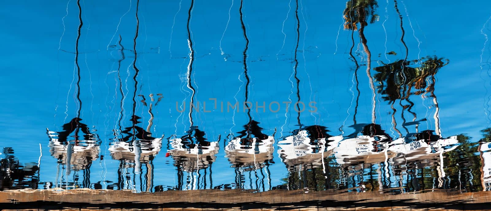 Water reflection of the line of sailboats docked in St. Petersburg, Florida