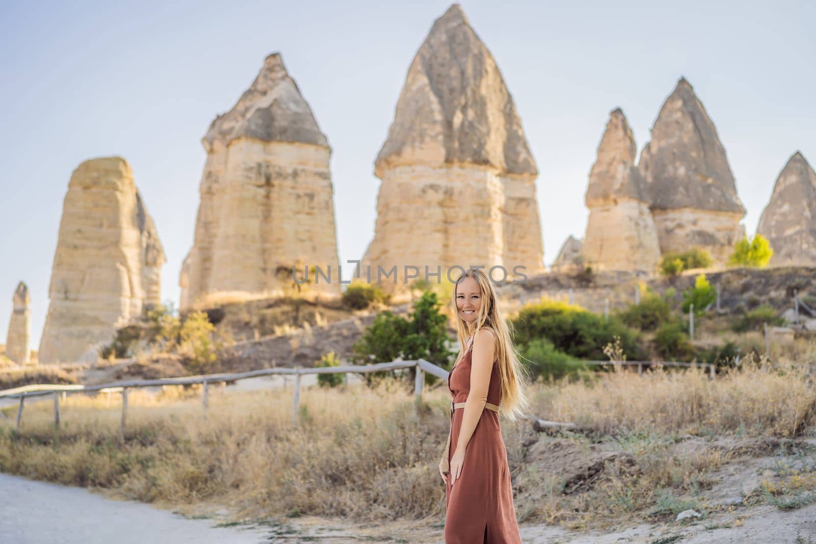 Woman tourist on background of Unique geological formations in Love Valley in Cappadocia, popular travel destination in Turkey.