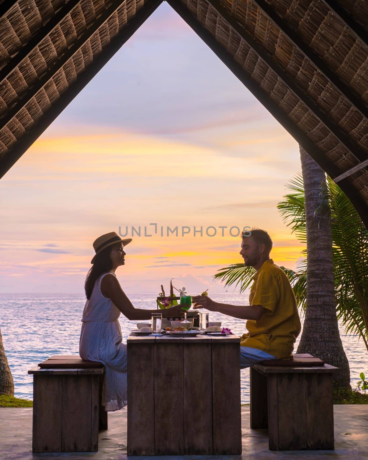 Couple having Romantic dinner on the beach with Thai food at sunset on the Island Koh Mak Thailand by fokkebok