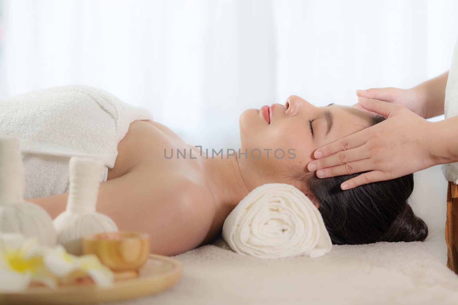 Young woman doing relaxing massage in spa salon. Female being massaged by a masseur. Spa and medicine concept.