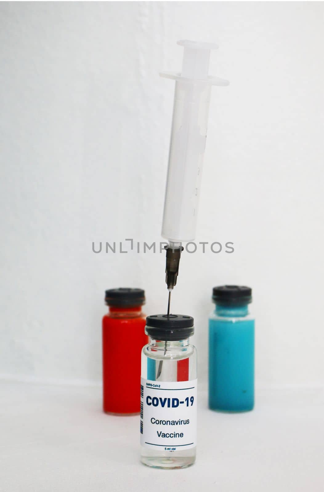 One ampoule with covid vaccine, blue and red ampoule with medicine to strengthen immunity.