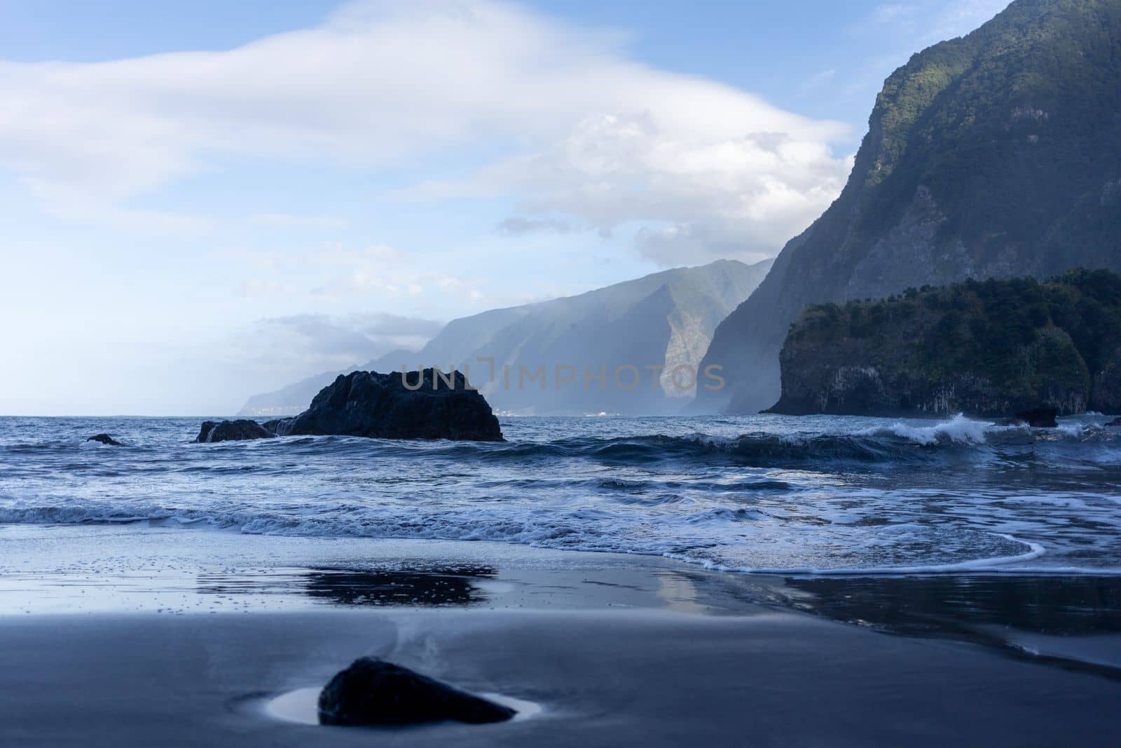 black sand beach of Madeira view on mountains by Chechotkin