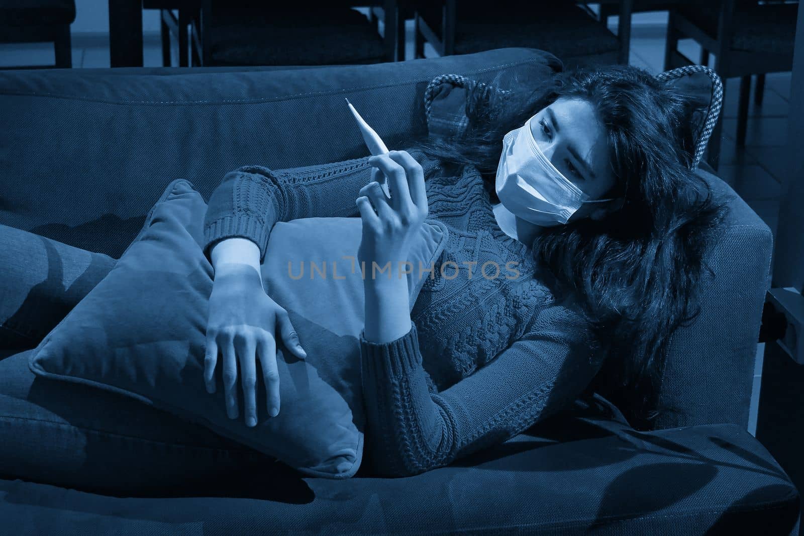 young woman holding thermometer on sofa got fever, caught, sick girl having influenza symptoms, flu or virus concept by Mariakray