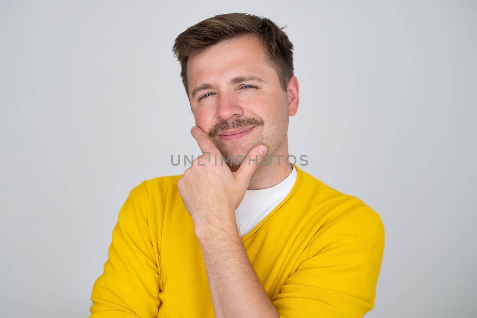 Thoughtful caucasian young man touch chin with finger thinking or considering, pensive European man making decision or imagining