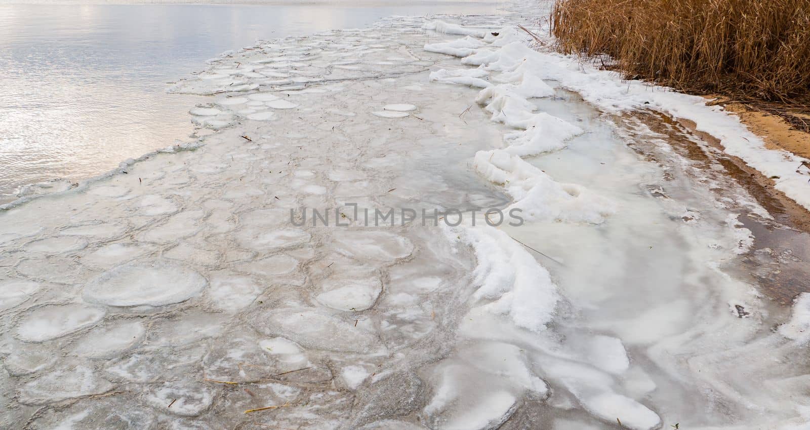 The surface of a freezing lake in autumn in bad weather. by gelog67