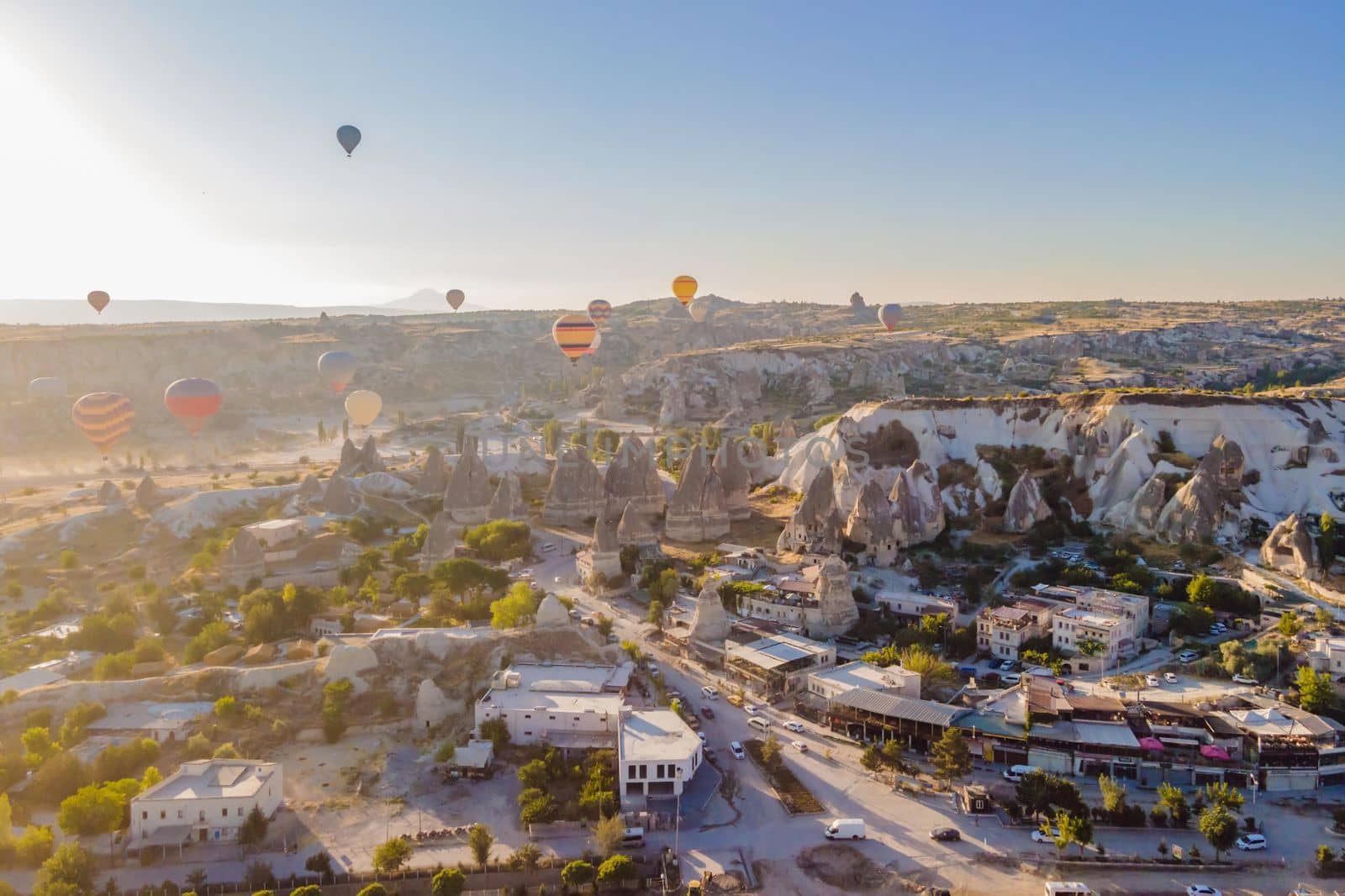 Colorful hot air balloons flying over at fairy chimneys valley in Nevsehir, Goreme, Cappadocia Turkey. Spectacular panoramic drone view of the underground city and ballooning tourism. High quality by galitskaya