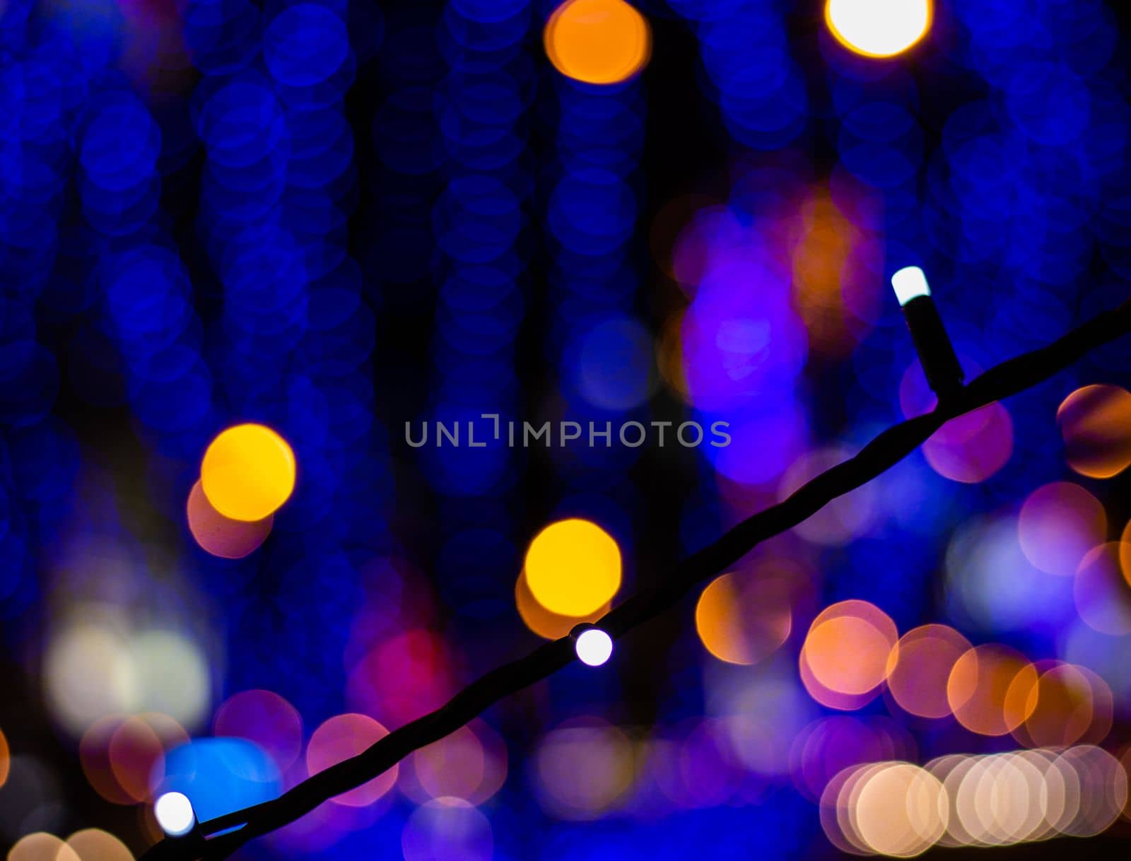 Christmas Winter Bokeh Light Blue Tones Background. Holiday lighting at night. Bokeh of garlands..